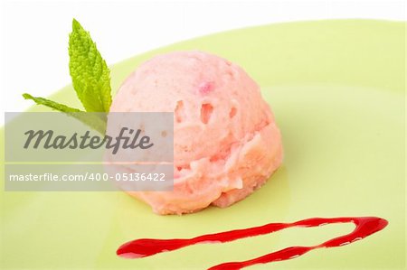 Delicious raspberries ice cream with syrup in green plate. Shallow depth of field