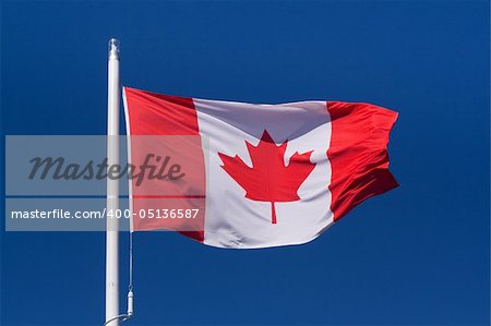 Waving flag of Canada against the clear blue sky
