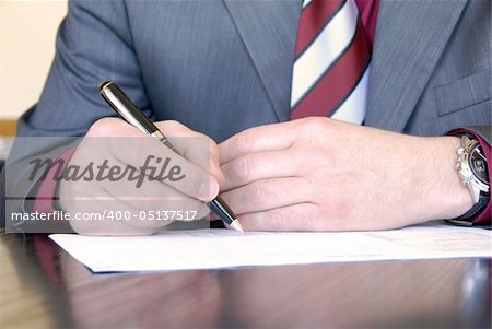 businessman hands on desk signing a document