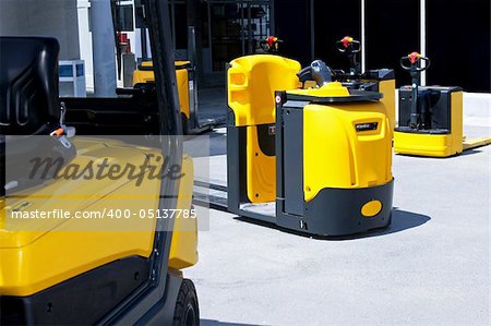 Yellow cargo pallet transporters and fork lifters