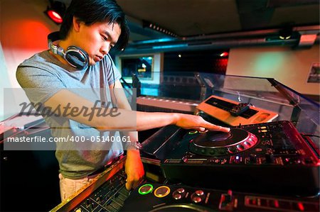 DJ working on the faders and turntables during his act in a club