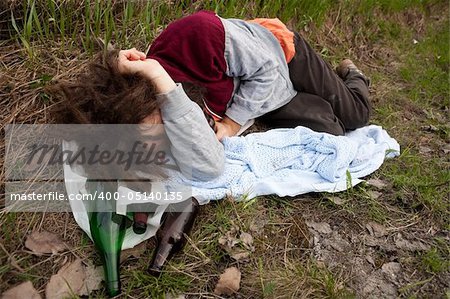 A drunk passed out in the ditch with a bunch of alcohol bottles