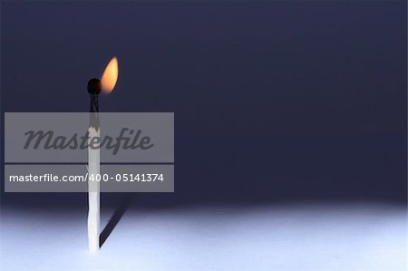 A lone burning match standing on gradient background. Horisontal image