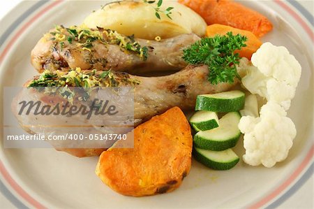 Delicious roasted chicken drumsticks with baked vegetables.
