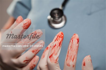 Abstract of Doctors Bloody Surgical Gloves, Scrubs and Stethoscope.