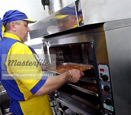 a cook inserts a dish in the oven