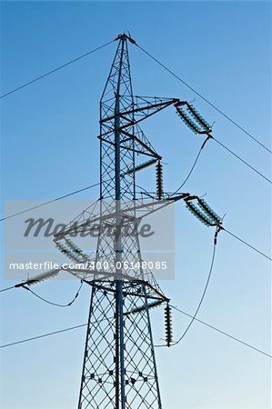 High voltage pylon with cables on blue sky background