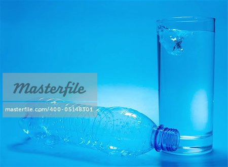 Empty bottle and glass full of water