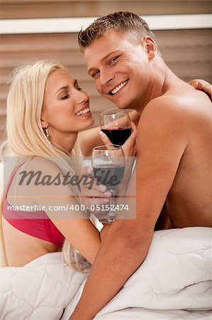 Couple sharing wine in bed