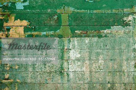 Green surface of the old, semidecayed wall covered with boards