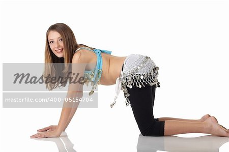 Young Caucasian belly dancing girl in beautiful decorated clothes on white background and reflective floor. Not isolated