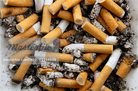 Ashtray full of burnt cigarettes. Dirty tobacco texture pattern