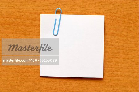 Paper note with a blue clip over the wooden table