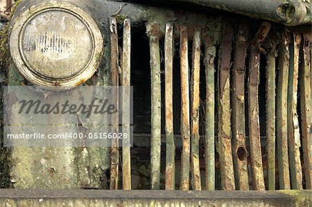 The exterior radiator grill from a old, abandoned and broken-down truck that has rusted out from top to bottom.