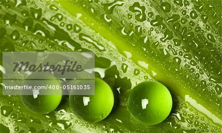 Water drops on green leaf and marbles - nature background