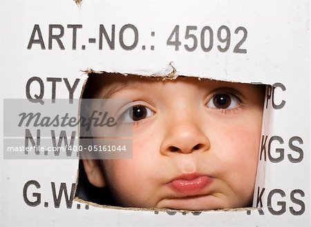 Bored kid peeking out from a labeled cardboard box