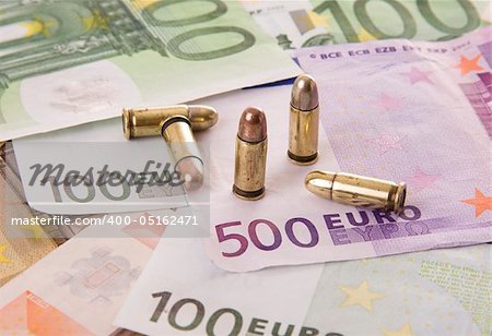 Five bullets and euro banknotes - Selective focus on the 500 euros