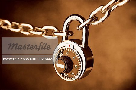 A Chain locked by a lock on brown background