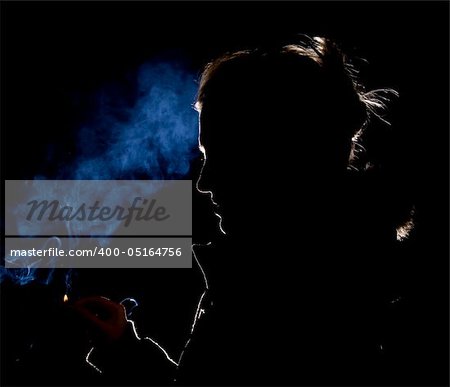 Silhouette or rim light of a Woman lighting a match with blue smoke