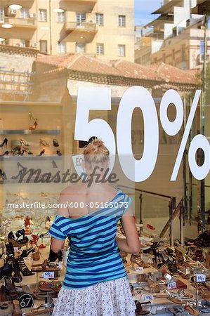 Woman in front of a shop Window With Sale Banners. Shopping Series.