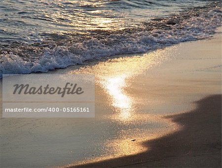 evening sea sandy shore with sunlight path