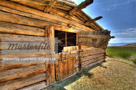 A deserted log barn shot in HDR.