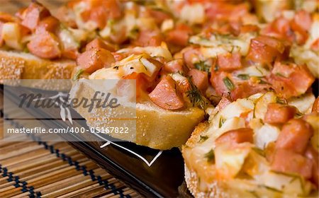 Baked pizza sandwiches on a black plate