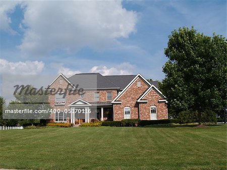 Two story large brick residential home with flower box.