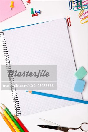 Set of pencils, erasers, post-its and other useful supplies for the school. There is a centered blank notebook for text writing