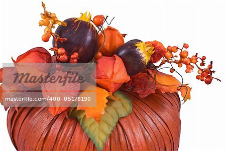 Artificial orange pumpkin decorated with leaves, flowers and berries