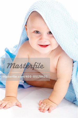 Smiling baby covered with a towel