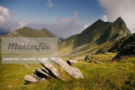 Mountain valley with rocks and green grass on summer day in wilderness romanian carpathians