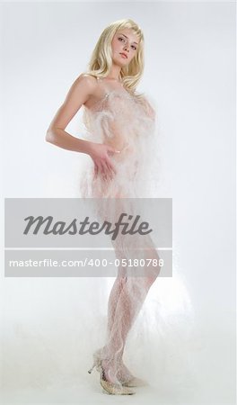 Nude woman in white fabric on white background