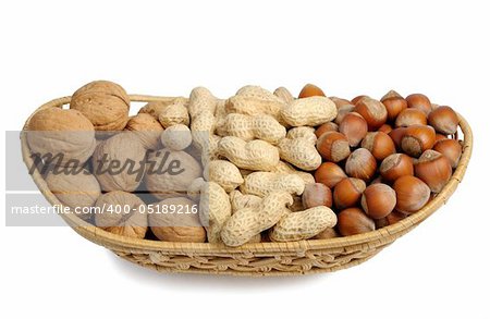 Walnuts, hazelnuts and peanuts in a wicker basket on a white background, isolated