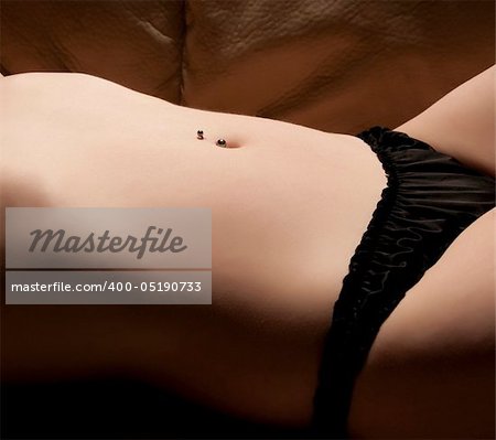 Nude woman body with a navel piercing