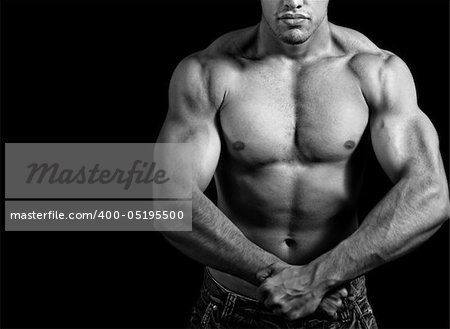 Big athletic man showing his muscles over black background