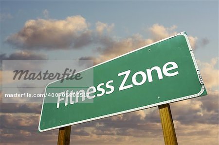 Fitness Zone Green Road Sign In Front of Dramatic Clouds and Sky.