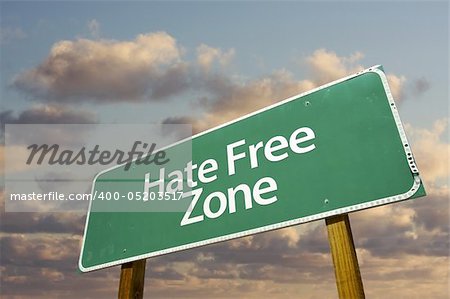 Hate Free Green Road Sign In Front of Dramatic Clouds and Sky.