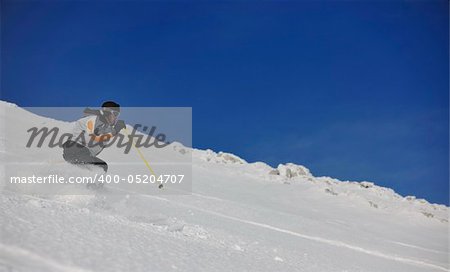 skier free ride downhill at winter season on beautiful sunny day