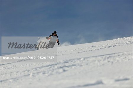 skier free ride downhill at winter season on beautiful sunny day