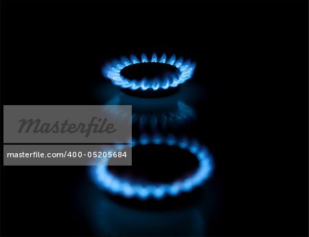 Two gas stove burners with blue flames. Illustration of traditional energy sources.  Shallow depth-of-field.