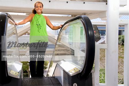 A beautiful young woman on an esclator at a shopping center