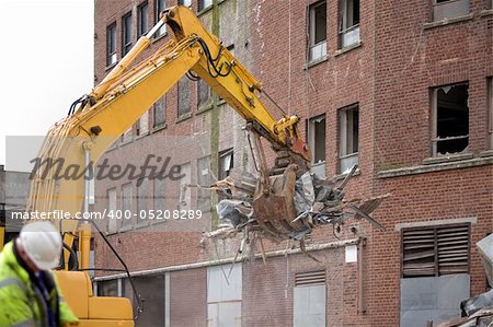 demolition squad destroy an old building to start a new development