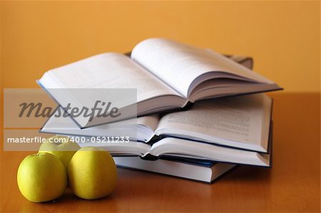 three green apples and opened books