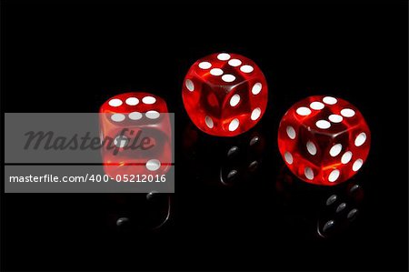 Three casino dice on a black background