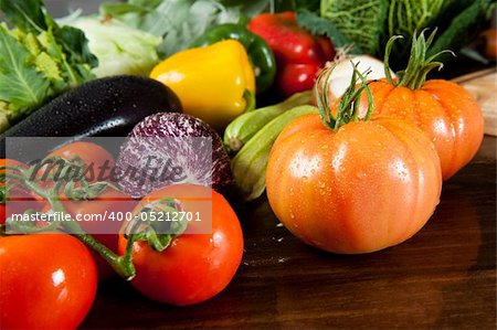 a wooden table spread of fresh vegetables