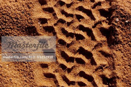 Dirt background with vehicle pattern track