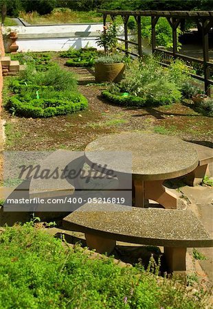 Large herb garden with stone table and different herbs