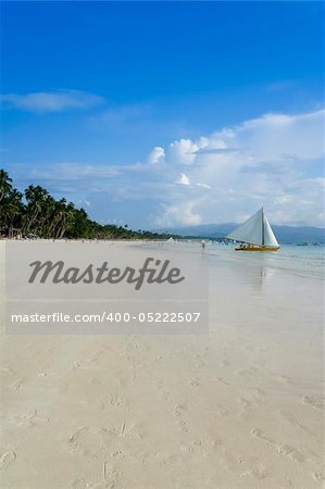 traditional paraw sailing boats on white beach on boracay island in the philippines