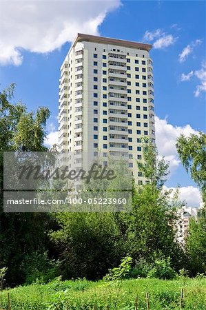 Modern apartment building under blue sky in a green district